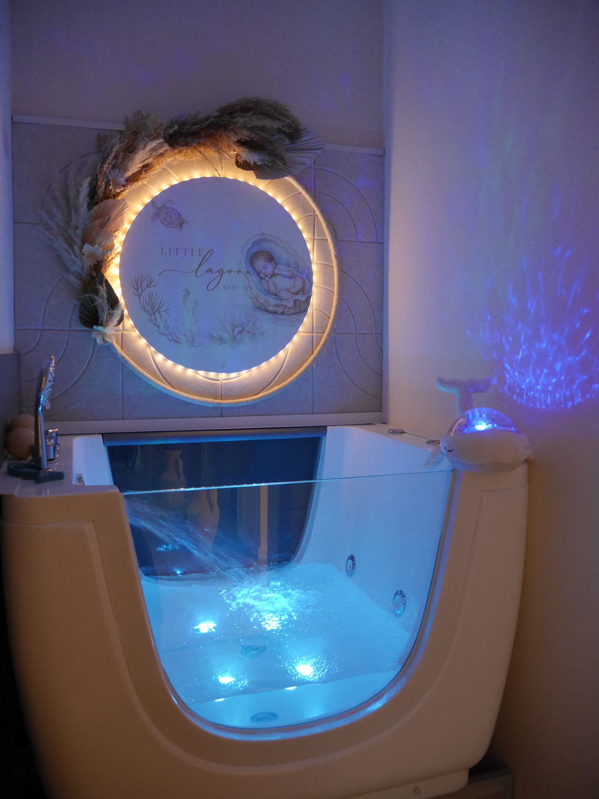 Das sanft beleuchtete Floating-Becken im gedämpften Licht unter dem leuchtenden Little-Lagoon-Logo
